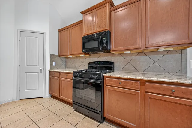 a kitchen with granite countertop cabinets stainless steel appliances and a sink