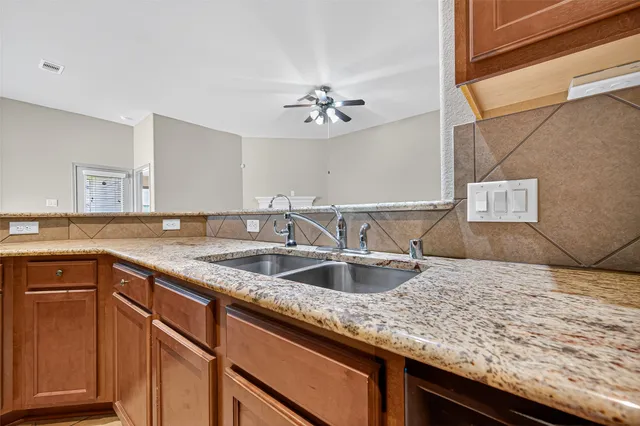 a kitchen with granite countertop a sink and a wooden cabinets
