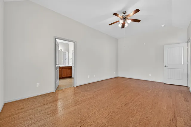 a view of an empty room with a ceiling fan and a ceiling fan