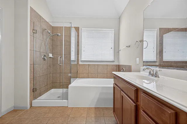 a bathroom with a granite countertop sink a toilet a mirror and shower