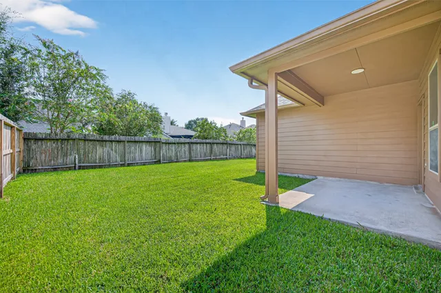 a view of a backyard with wooden fence