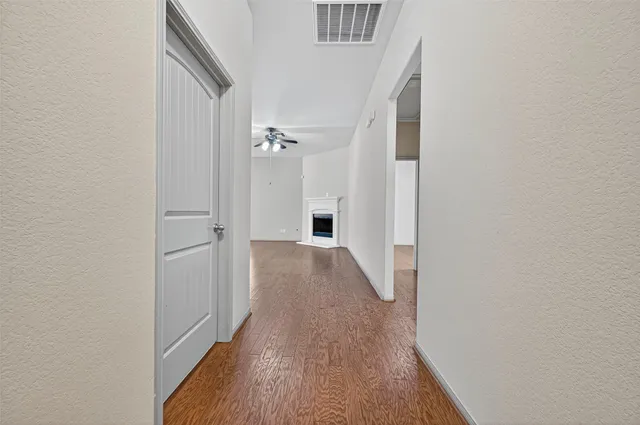 a view of a hallway with wooden floor and staircase