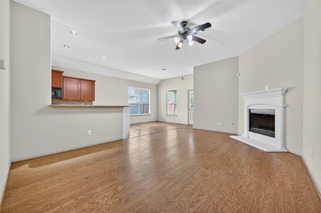 a view of an empty room with chandelier and fireplace
