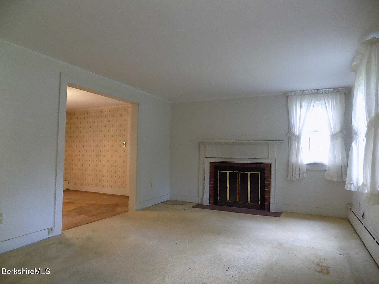 350 Laurel Street Lee, MA 01238 - Photo 2 of 34 an empty room with a fireplace and window