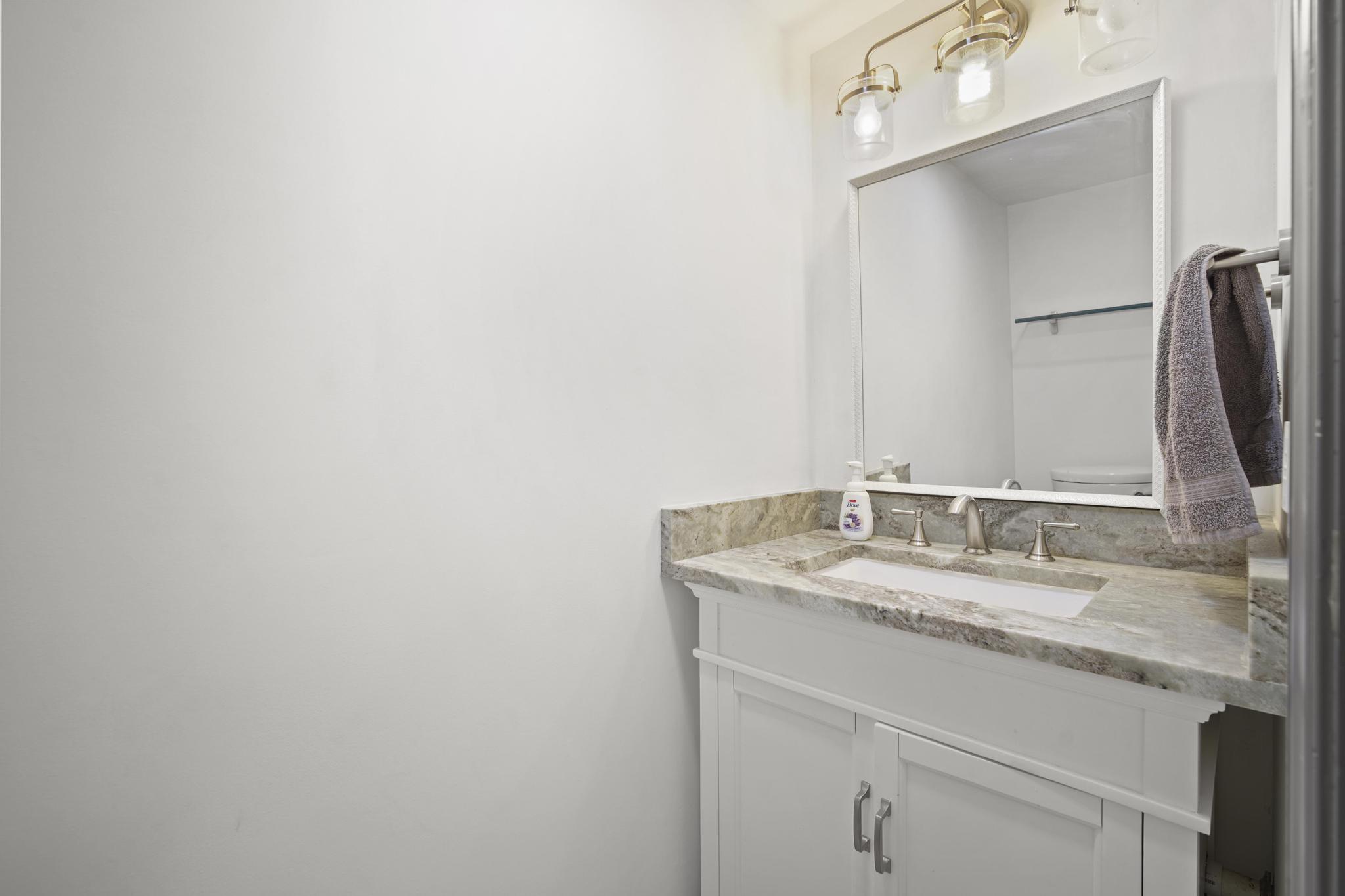 149 Northwest 70th Street, Unit 214C Boca Raton, FL 33487 - Photo 12 of 35 a bathroom with a granite countertop sink and a mirror