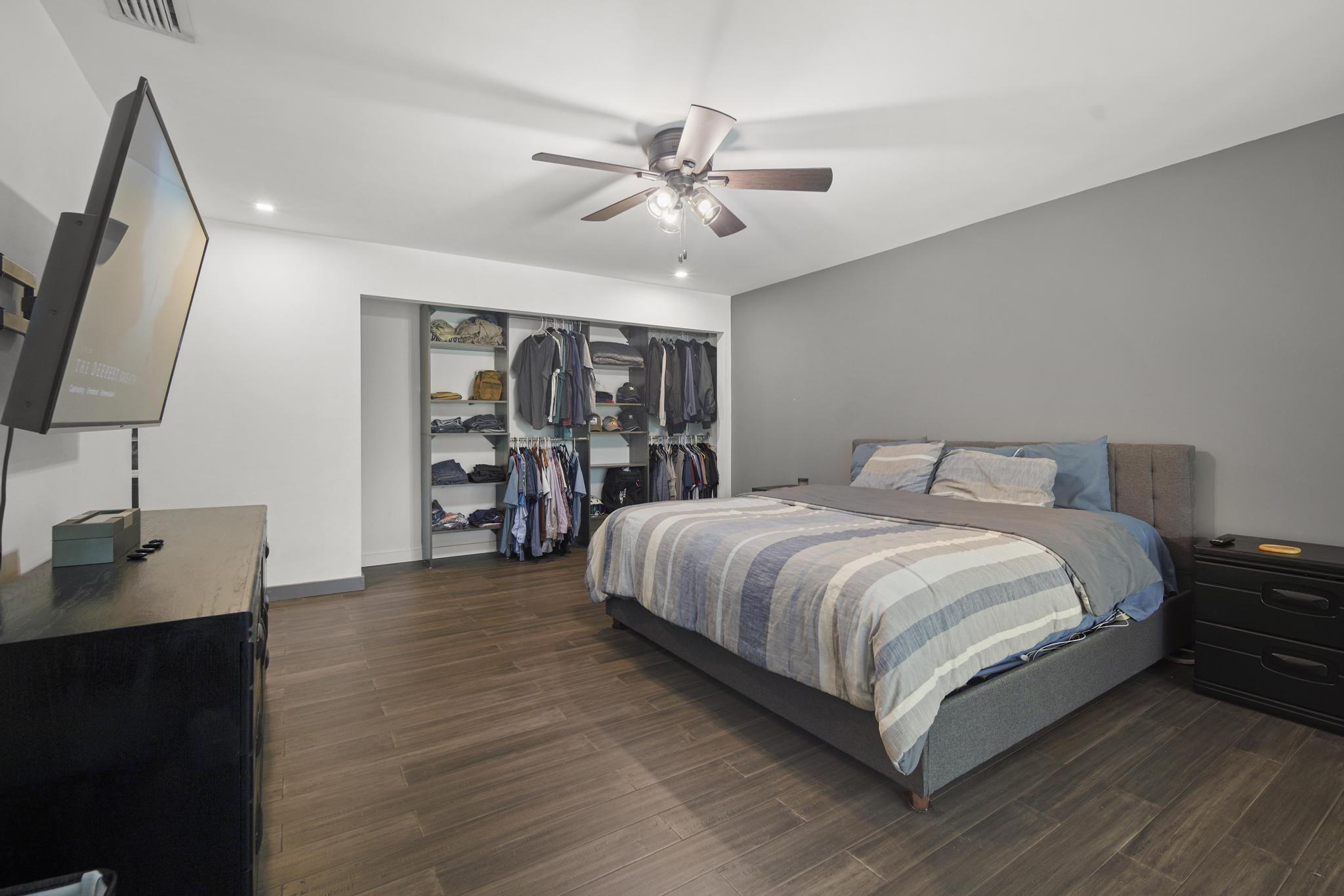 149 Northwest 70th Street, Unit 214C Boca Raton, FL 33487 - Photo 17 of 35 a bedroom with a large bed and a flat tv screen on a dresser