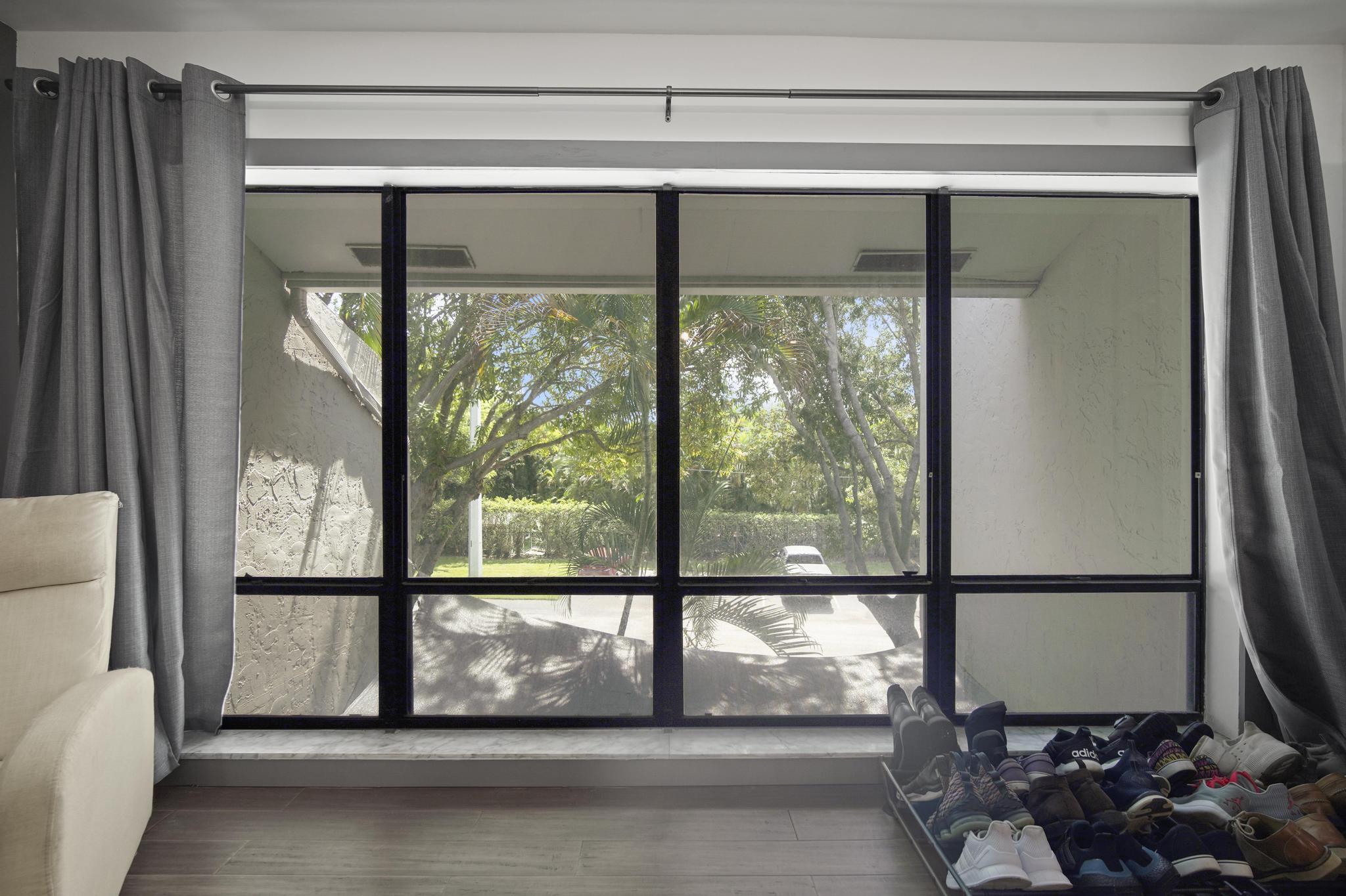 149 Northwest 70th Street, Unit 214C Boca Raton, FL 33487 - Photo 18 of 35 a view of a glass door with a tv on the wall