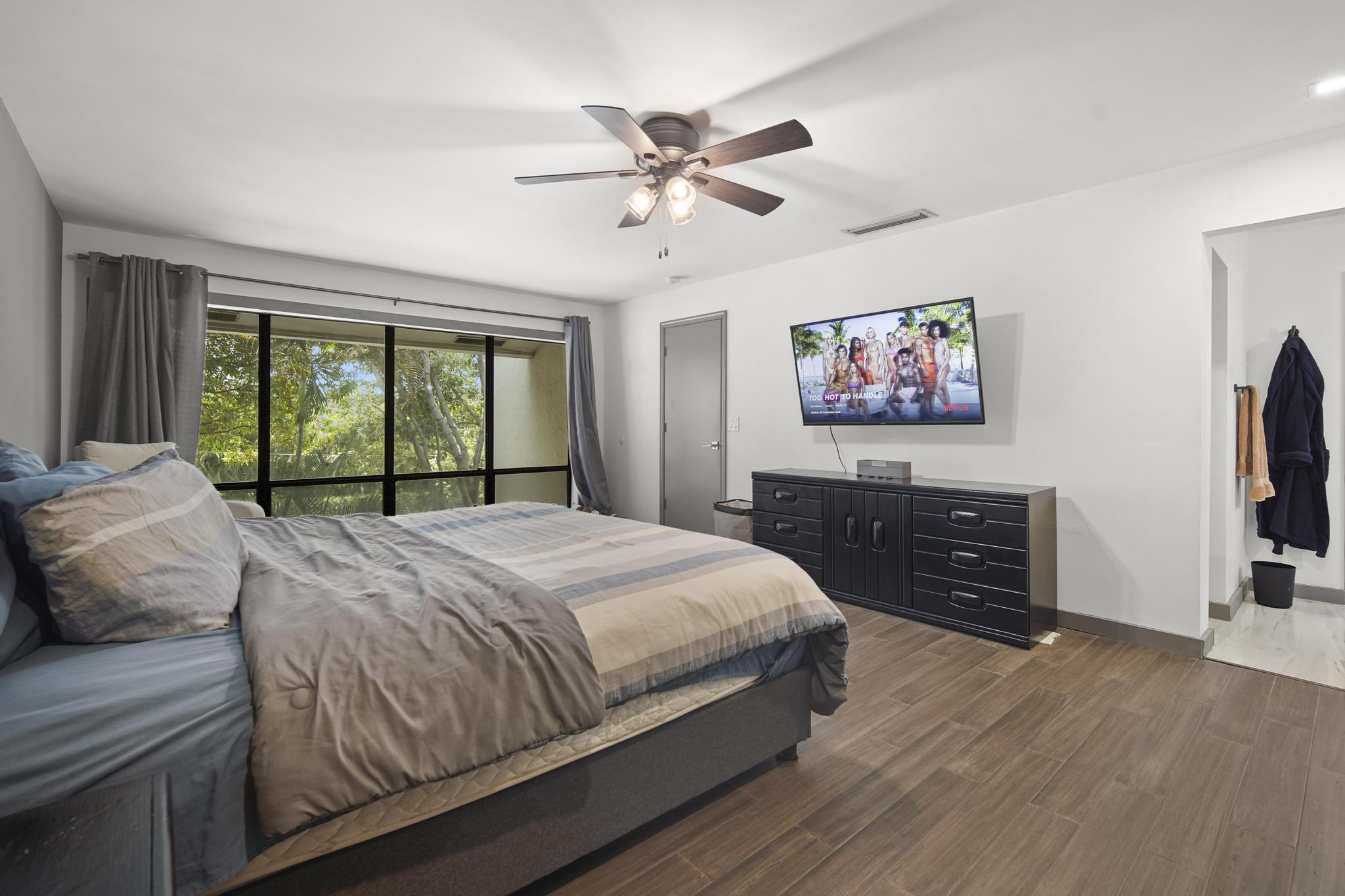 149 Northwest 70th Street, Unit 214C Boca Raton, FL 33487 - Photo 19 of 35 a bedroom with a bed and a flat screen tv