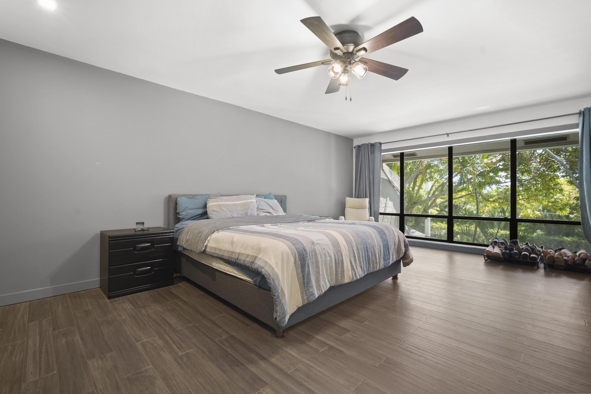 149 Northwest 70th Street, Unit 214C Boca Raton, FL 33487 - Photo 20 of 35 a bedroom with a large bed and a large window