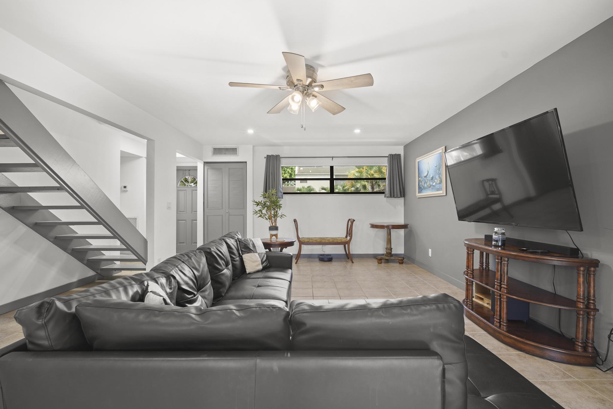 149 Northwest 70th Street, Unit 214C Boca Raton, FL 33487 - Photo 2 of 35 a living room with furniture and a flat screen tv