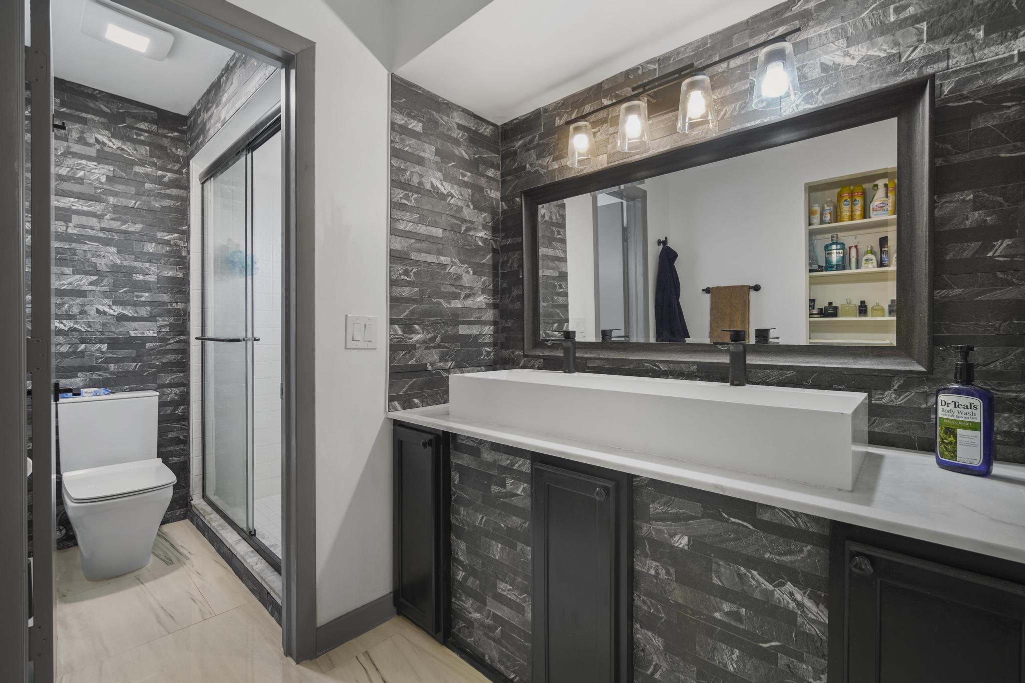 149 Northwest 70th Street, Unit 214C Boca Raton, FL 33487 - Photo 22 of 35 a bathroom with a double vanity sink and a toilet