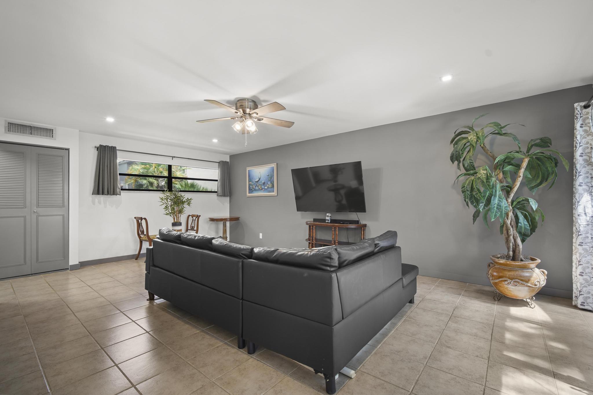 149 Northwest 70th Street, Unit 214C Boca Raton, FL 33487 - Photo 3 of 35 a living room with furniture a potted plant and a flat screen tv
