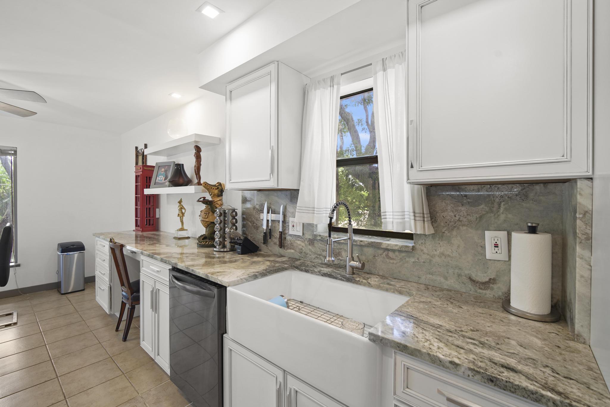 149 Northwest 70th Street, Unit 214C Boca Raton, FL 33487 - Photo 5 of 35 a kitchen with a sink stove and cabinets