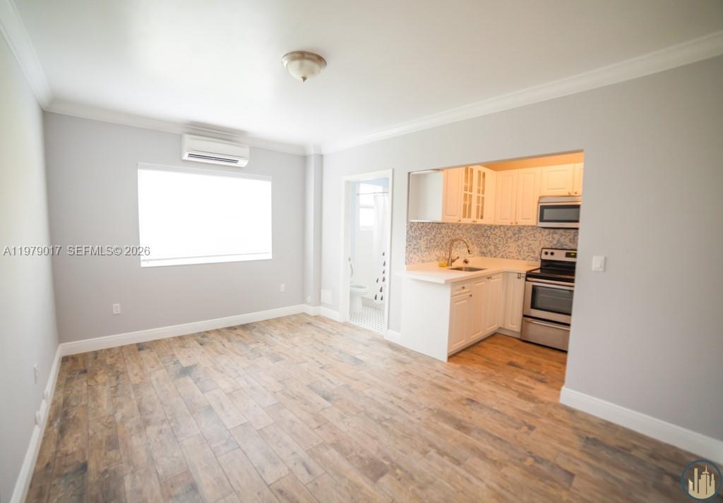 a view of a kitchen with wooden floor and a window