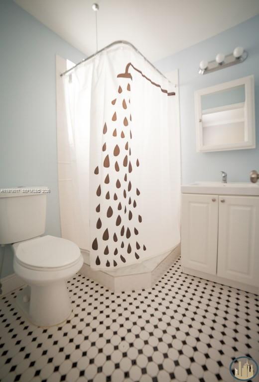 53 Northeast 49th Street, Unit 7 Miami, FL 33137 - Photo 3 of 5 a bathroom with a sink a toilet a window and a mirror