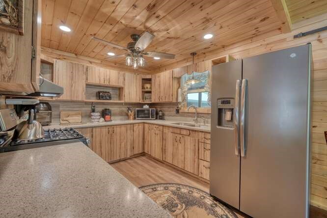 245 Panther Hill Road Murphy, NC 28906 - Photo 19 of 57 a kitchen with kitchen island granite countertop a refrigerator a sink a stove a microwave and cabinets