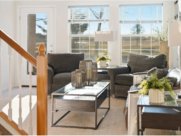 a living room with furniture and a floor to ceiling window