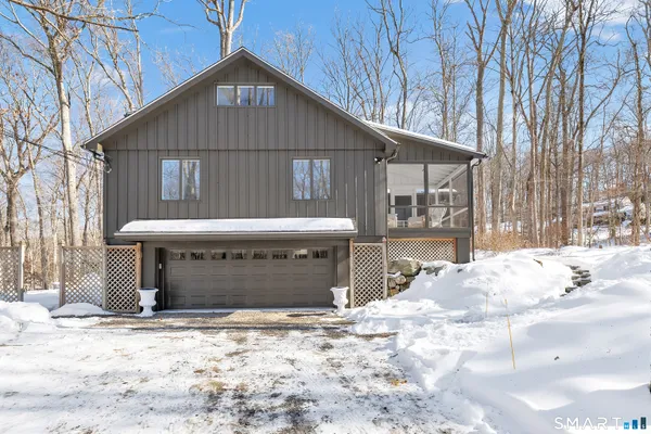 a front view of a house with a yard covered in snow