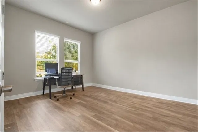 a view of a workspace with furniture and a window