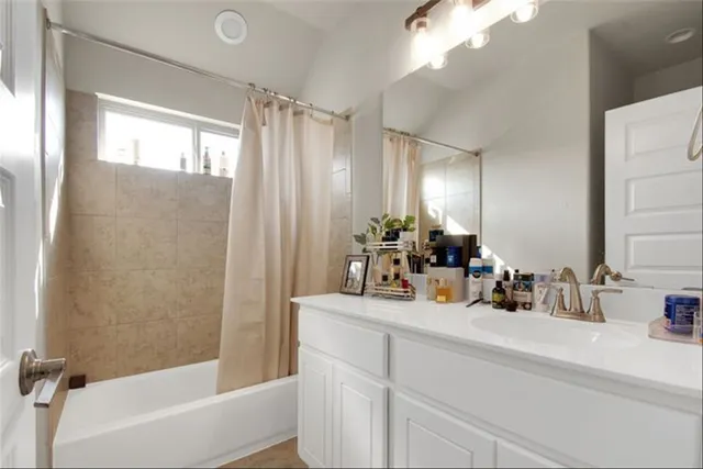 a bathroom with a sink a large mirror and a bathtub