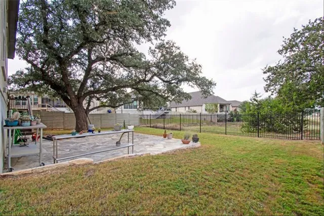a view of a house with backyard and tree