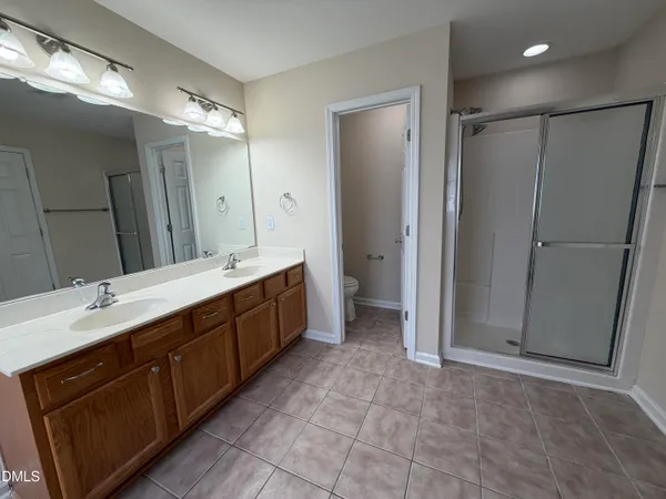 a spacious bathroom with a double vanity sink mirror and shower