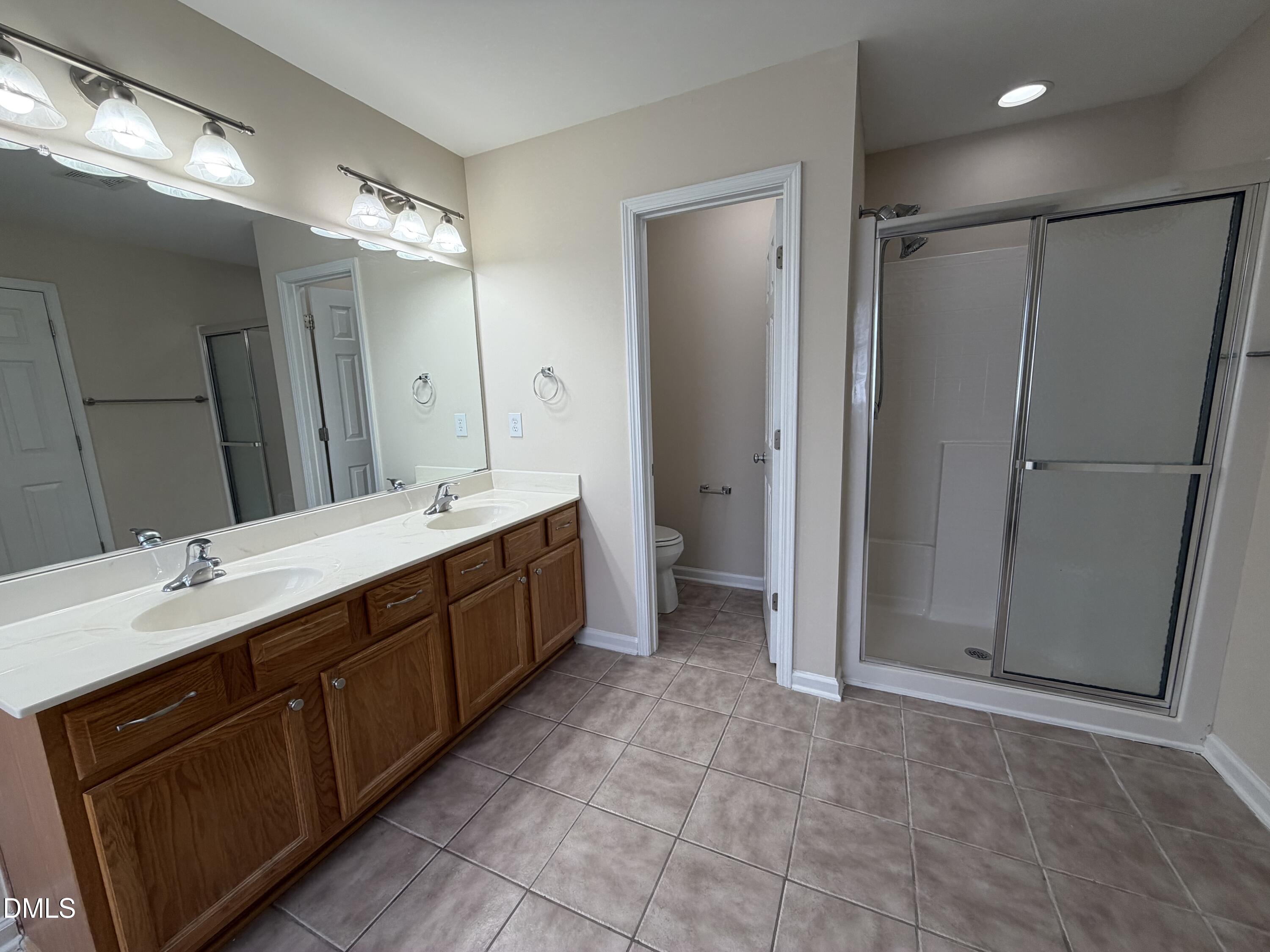 2418 Lazy River Drive Raleigh, NC 27610 - Photo 12 of 14 a spacious bathroom with a double vanity sink mirror and shower