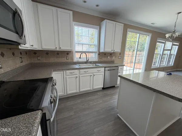 a kitchen with a sink stove and cabinets