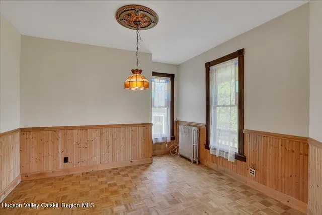 a view of a dining room with furniture a chandelier and wooden floor