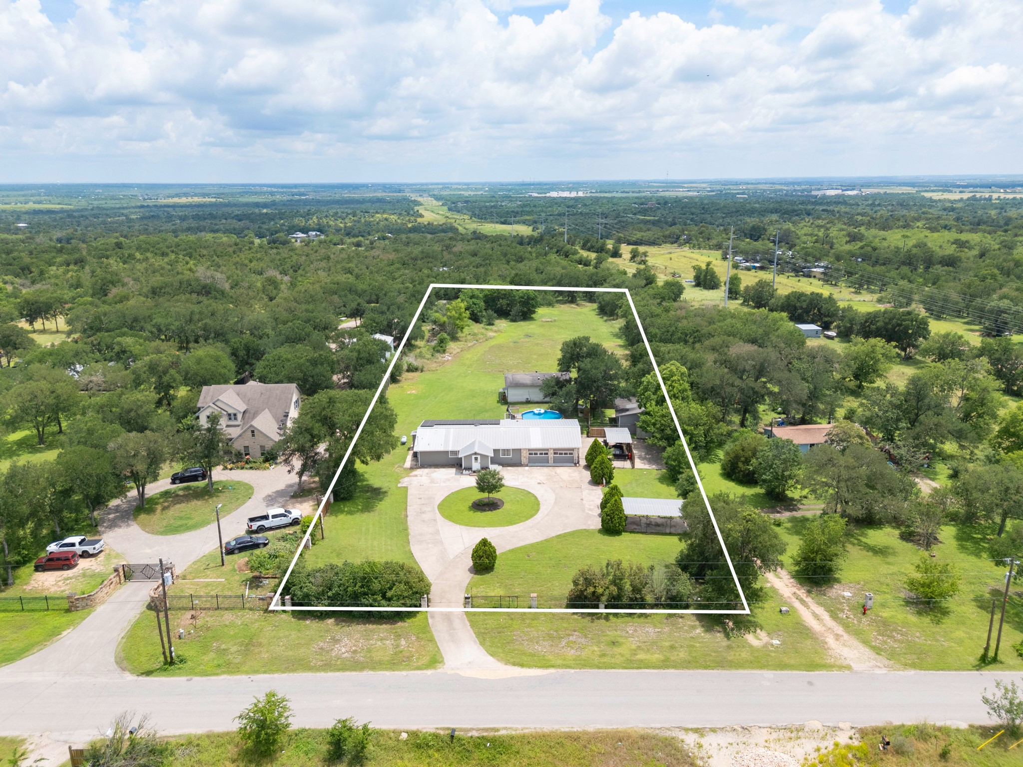 9725 Bock Road Buda, TX 78610 - Photo 25 of 32 An aerial perspective reveals a serene, expansive property featuring a welcoming circular driveway.