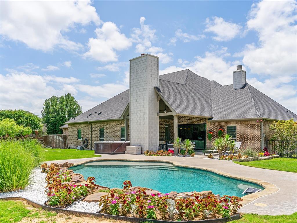 111 Old Base Road Aurora, TX 76078 - Photo 1 of 38 Resort-style saltwater pool and spa surrounded by professional landscaping and outdoor living spaces.
