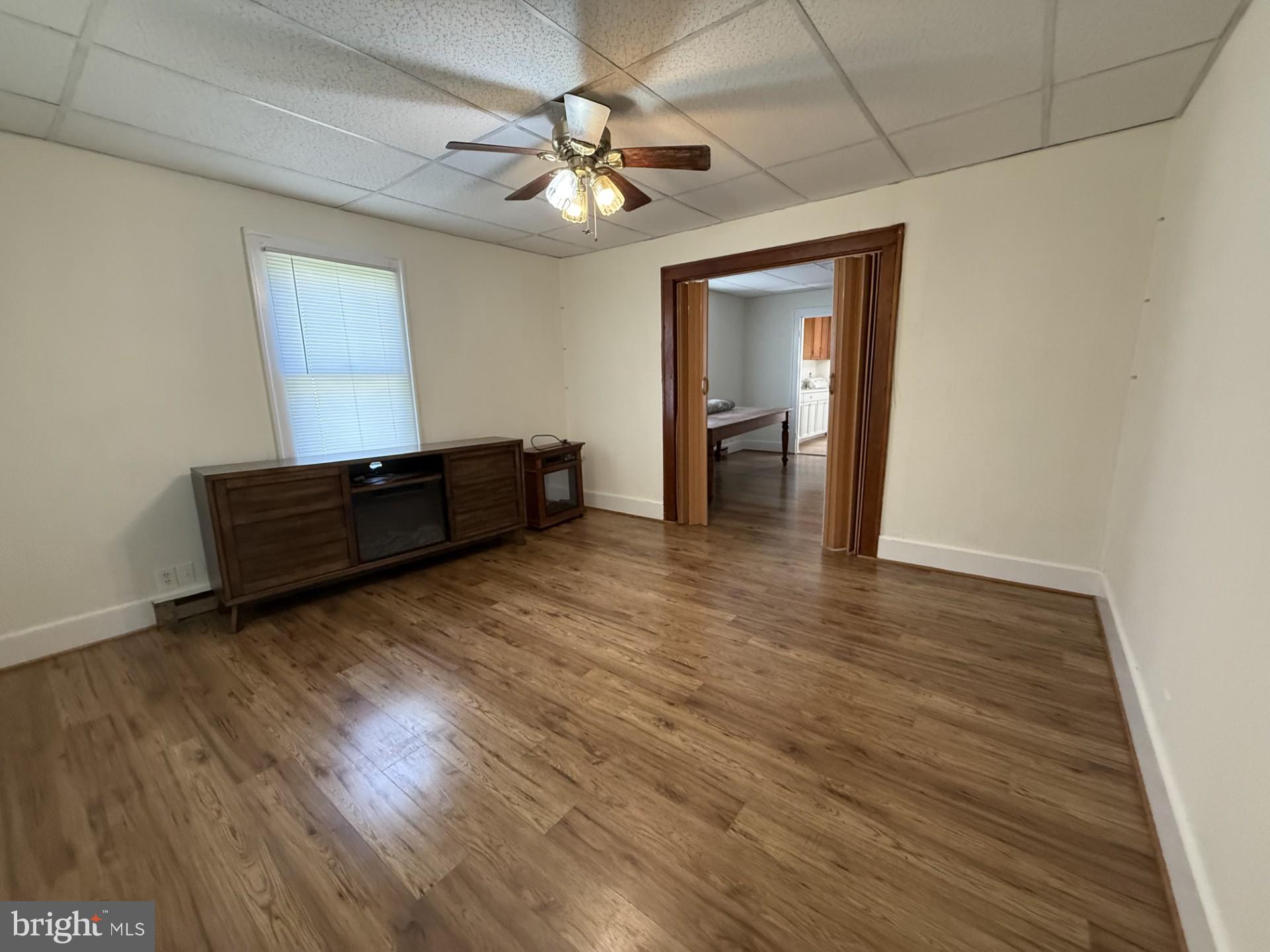 5497 Rosedale Drive King George, VA 22485 - Photo 9 of 12 an empty room with wooden floor chandelier fan and windows