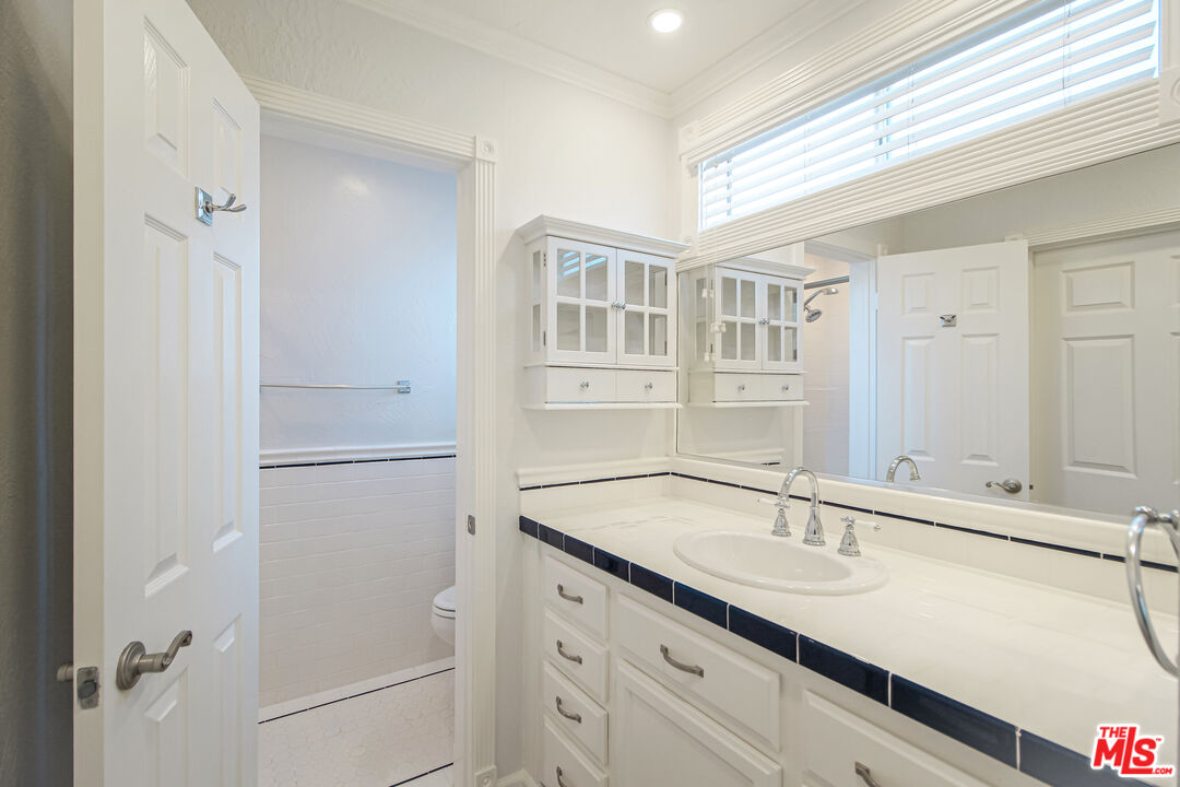 930 South Bedford Street, Unit 4 Los Angeles, CA 90035 - Photo 14 of 24 a bathroom with a sink and a mirror