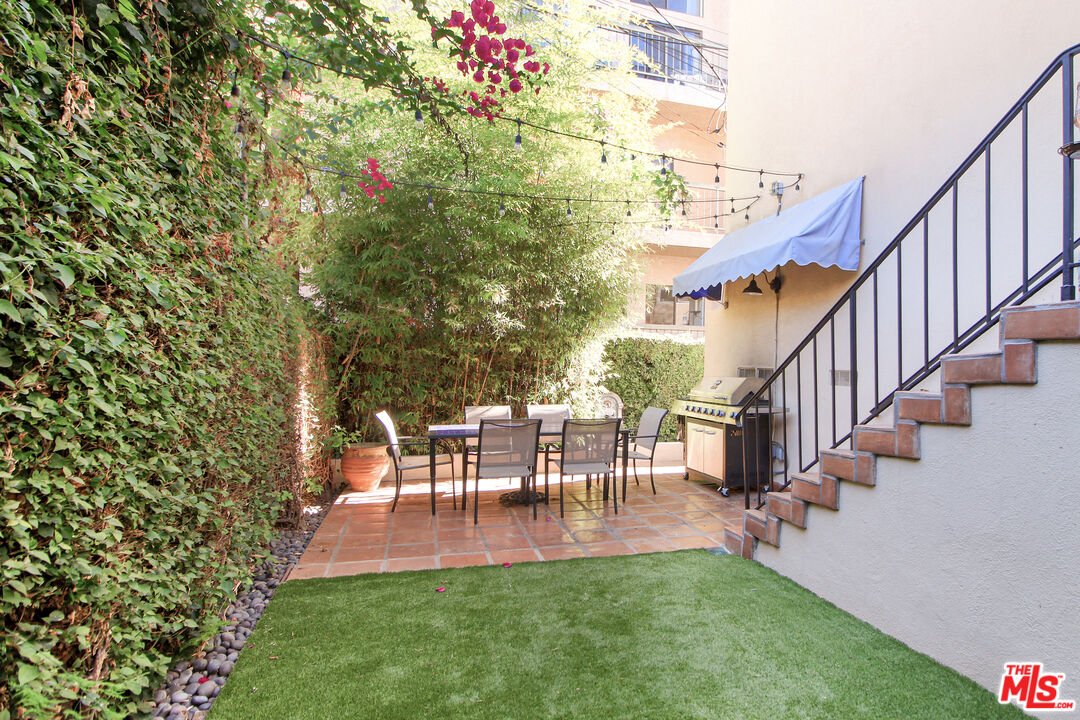 930 South Bedford Street, Unit 4 Los Angeles, CA 90035 - Photo 23 of 24 a view of a patio with table and chairs and potted plants