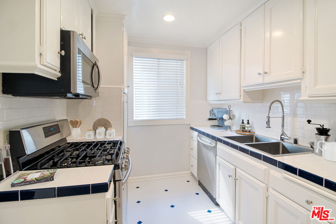 930 South Bedford Street, Unit 4 Los Angeles, CA 90035 - Photo 4 of 24 a kitchen with a sink a stove and cabinets