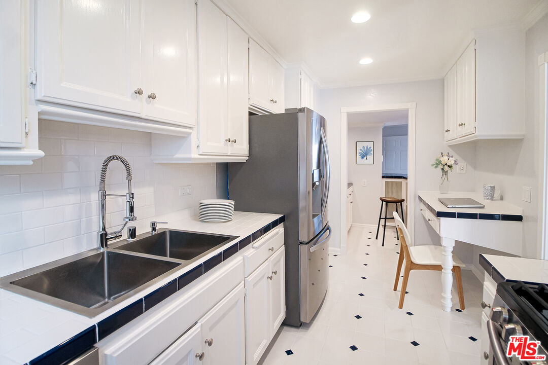 930 South Bedford Street, Unit 4 Los Angeles, CA 90035 - Photo 5 of 24 a kitchen with stainless steel appliances a sink a stove a refrigerator and cabinets