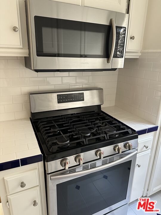 930 South Bedford Street, Unit 4 Los Angeles, CA 90035 - Photo 7 of 24 a stove top oven sitting inside of a kitchen