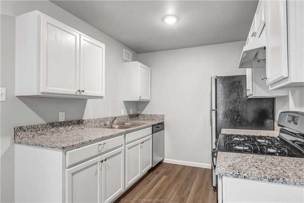 a kitchen with a sink stove and cabinets