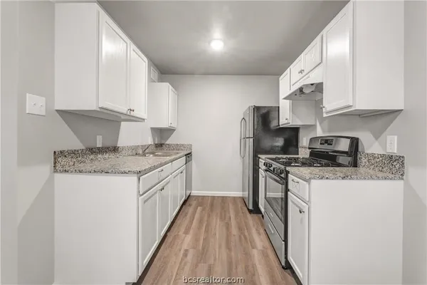 a kitchen with stainless steel appliances granite countertop a stove a sink and a refrigerator