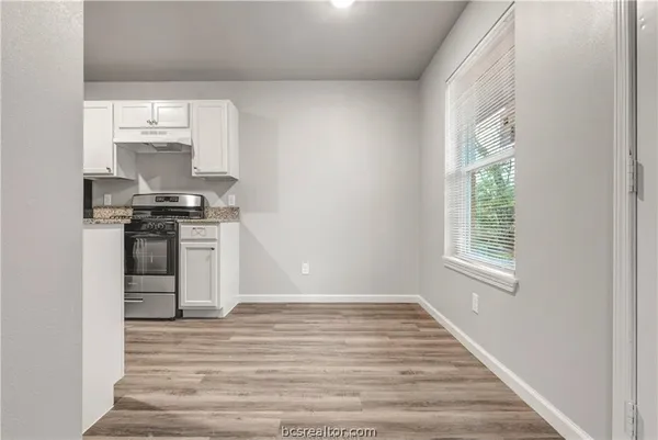 a kitchen with a stove a sink and a window