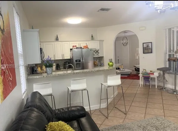 a living room with furniture a flat screen tv and kitchen island