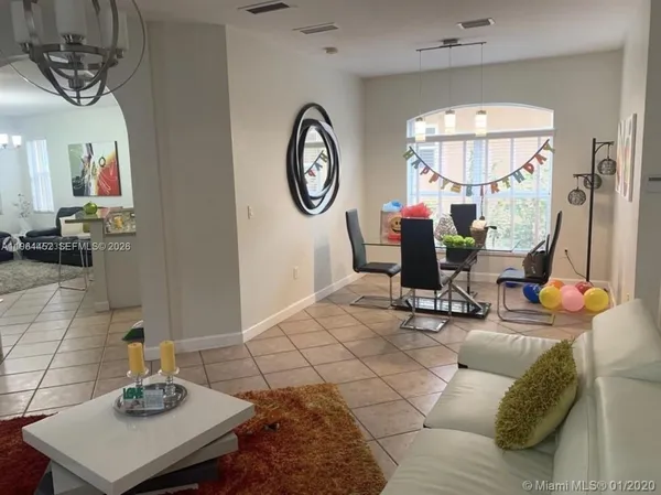 a living room with furniture a mirror and white walls