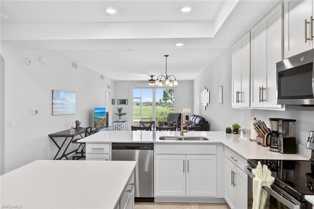 43985 Boardwalk Loop, Unit 2115 Punta Gorda, FL 33982 - Photo 5 of 28 a kitchen with stainless steel appliances a white cabinets counter space and a sink
