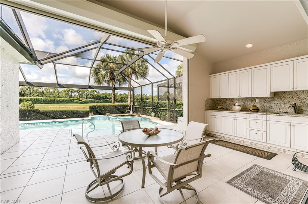 9156 Spring Run Boulevard Estero, FL 34135 - Photo 28 of 34 a kitchen with a table chairs and a stove