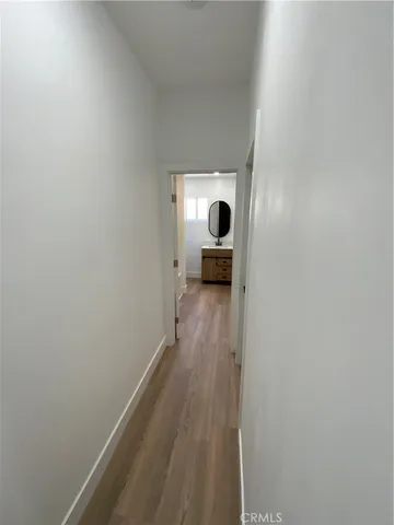 a view of a hallway with wooden floor and a cabinet