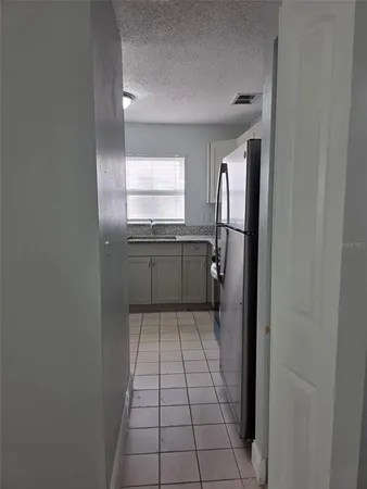 a kitchen with a sink a refrigerator and cabinets