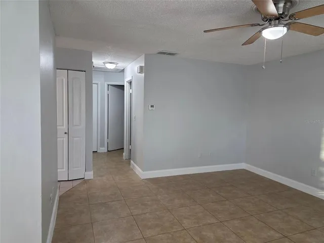 an empty room with closet and a chandelier fan