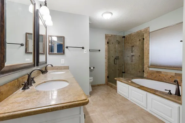 a spacious bathroom with a granite countertop tub sink and mirror