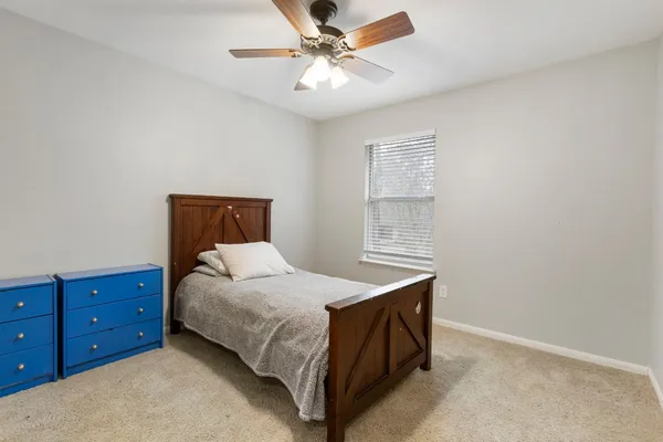 a bedroom with a bed dresser and a window