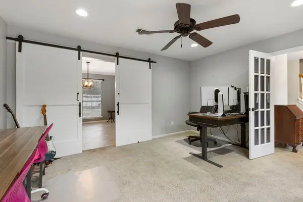 a view of a workspace with furniture and a ceiling fan